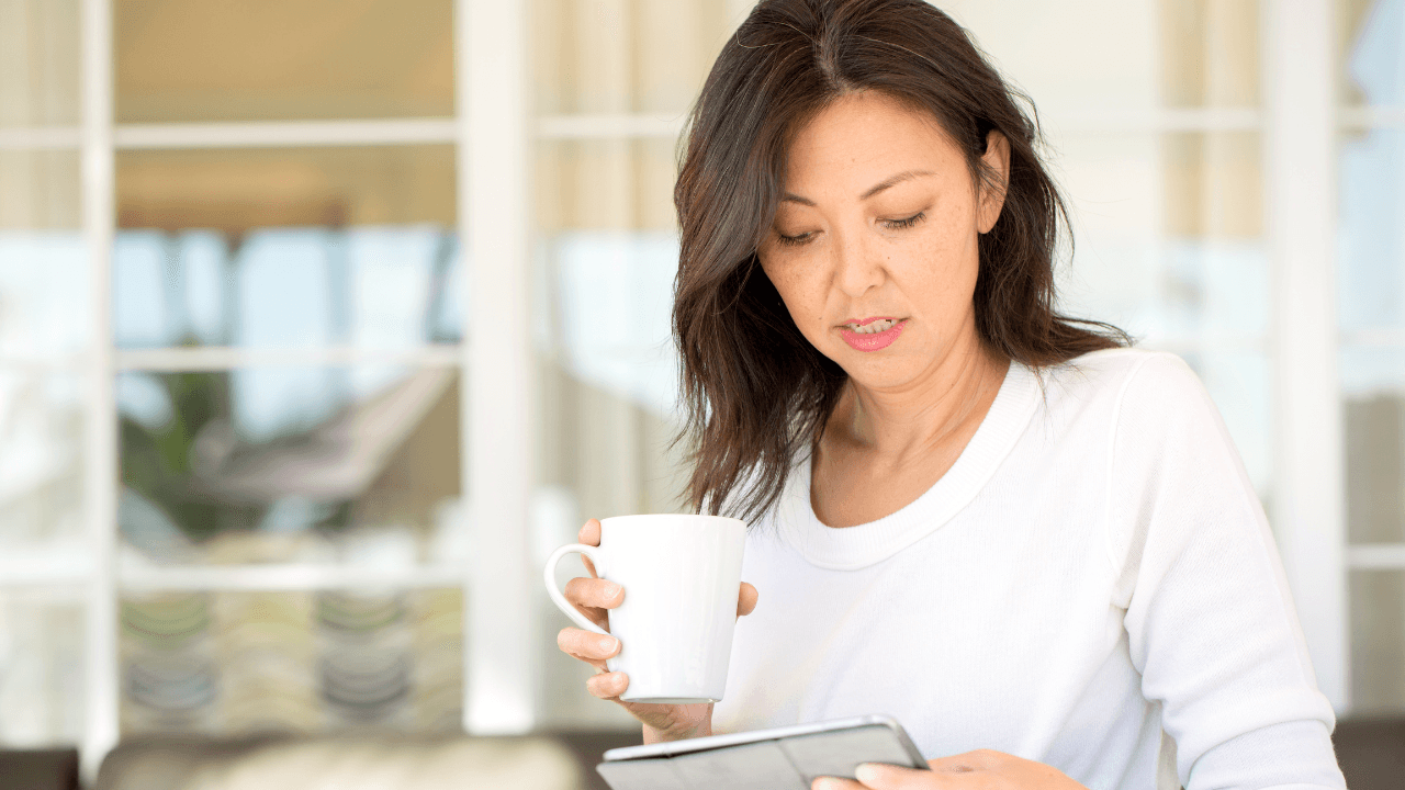 A woman with a cup of tea and a journal.